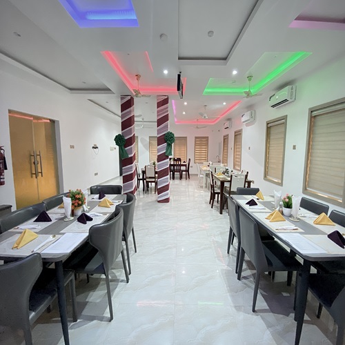 The hotel restaurant, with long dining tables set with napkins and flowers